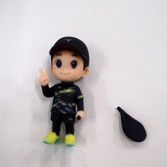 Small cartoon boy figure beside a detached black accessory